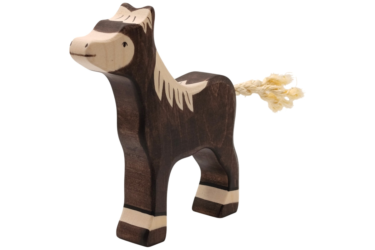 Holztiger Fohlen dunkelbraun stehend